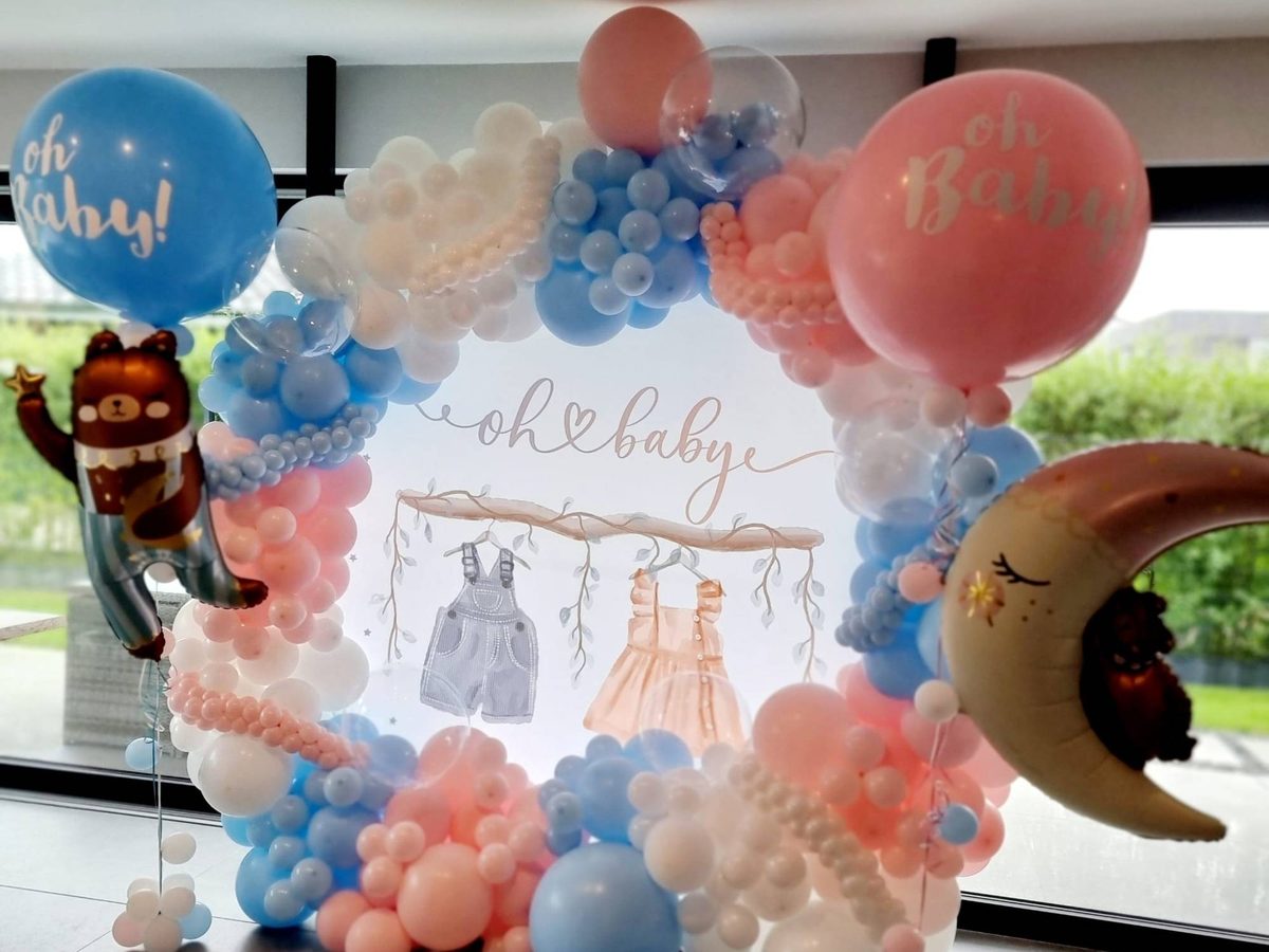Babyparty-Deko: Organic-Ballonring in Rosa, Hellblau und Weiß um ein „oh baby“-Backdrop, mit Oh-Baby-Ballons, Bären- und Mond-Folienballon