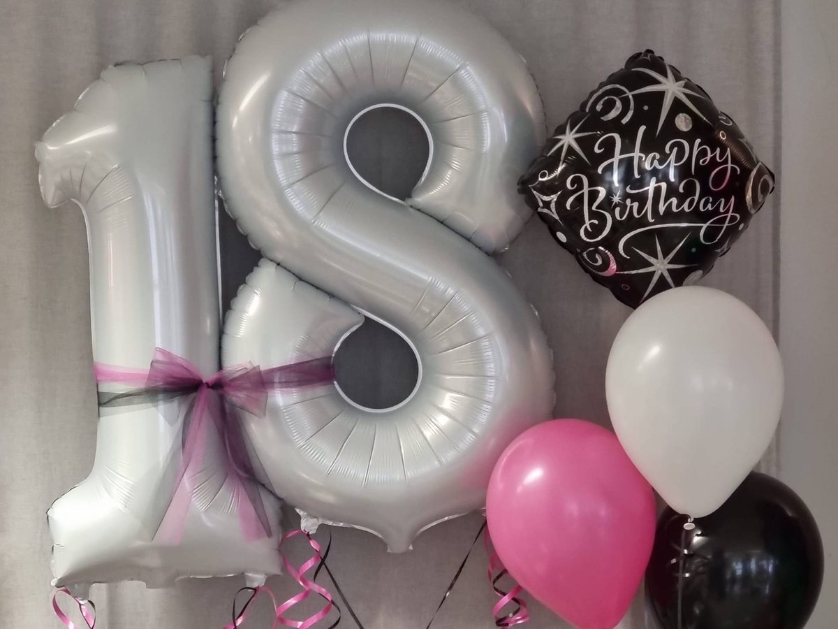 Ballongeschenk zum 18. Geburtstag: Folienzahlen 18 in Weiß mit Tüllschleife, Happy-Birthday-Ballon und Heliumballons in Pink, Weiß und Schwarz