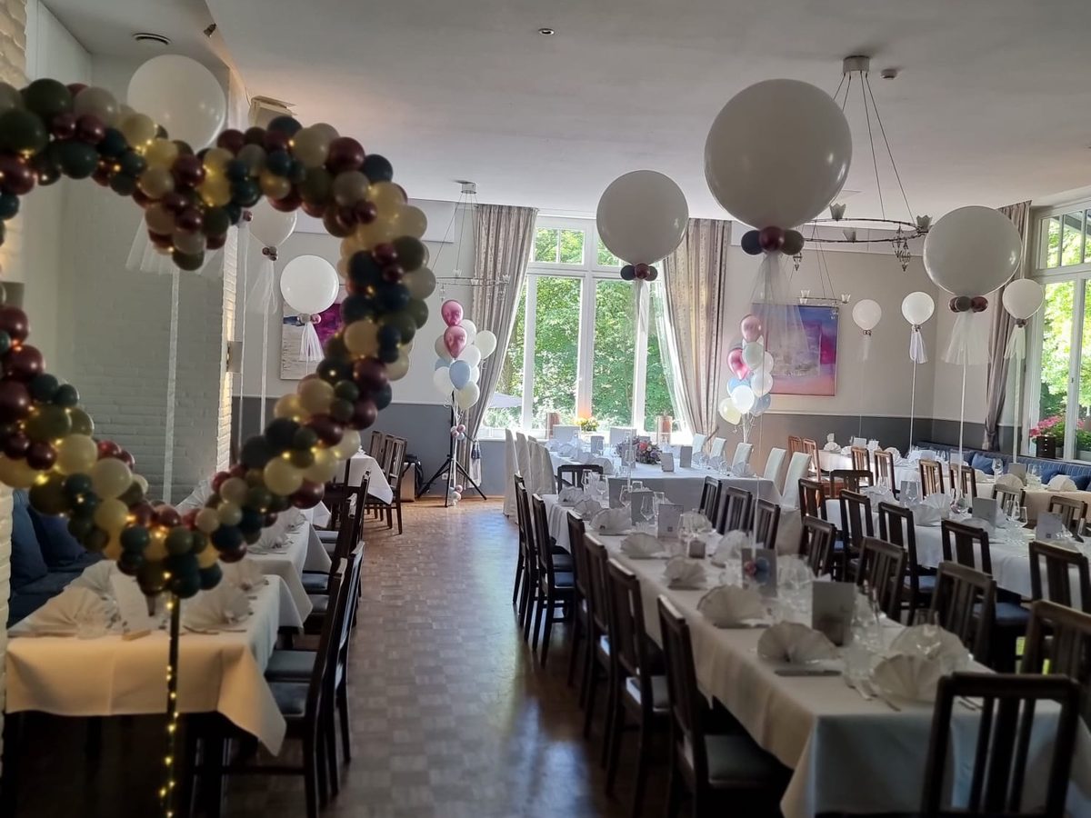 Hochzeitssaal mit Organic-Ballonherz in Bordeaux, Salbei und Creme, Riesenballons mit Tüll über den Tischen – Ballondeko von ZERALINO
