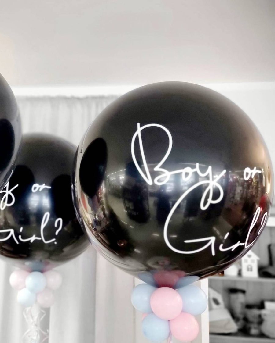 Drei große schwarze Ballons mit weißer Schrift „Boy or Girl?“ und Ballonkragen in Rosa und Hellblau