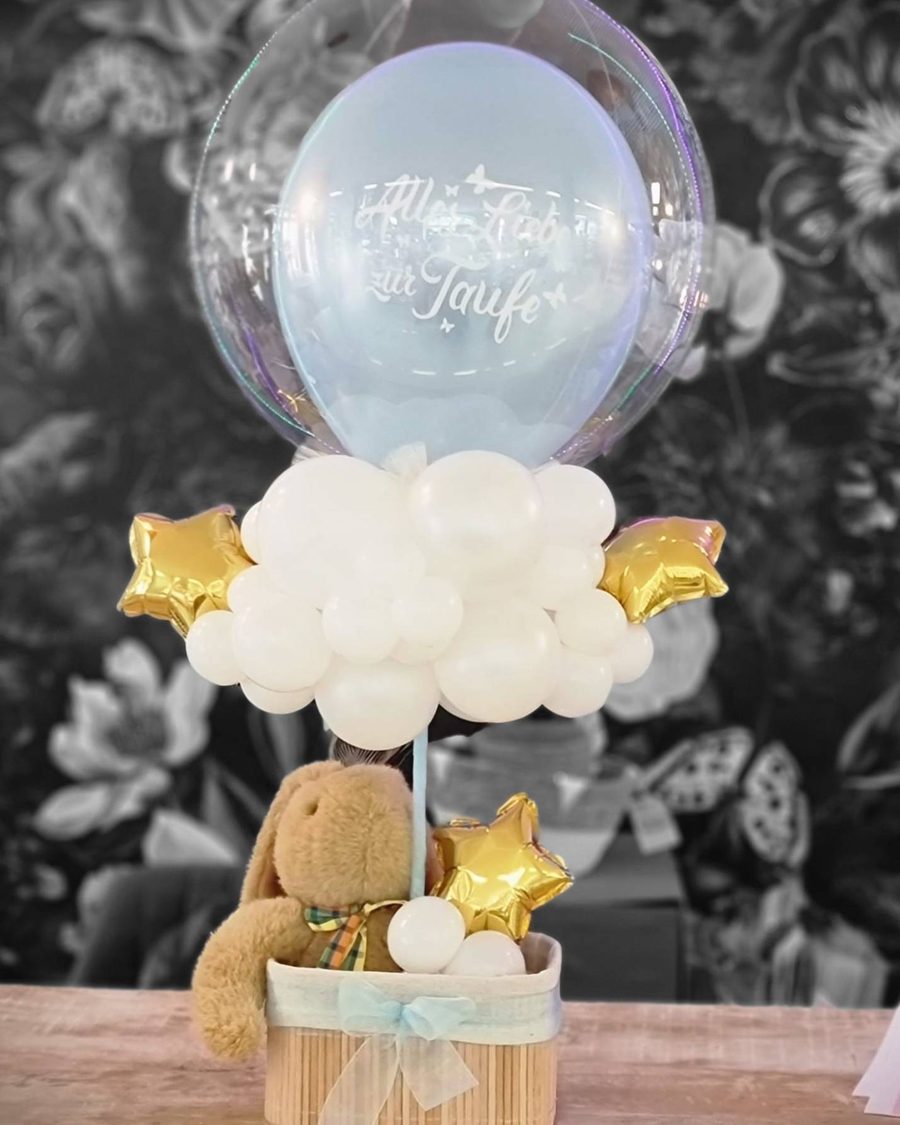 Heißluftballon aus Ballons: Bubble „Alles Liebe zur Taufe“ über einer Wolke aus weißen Ballons, im Korb ein Kuscheltier