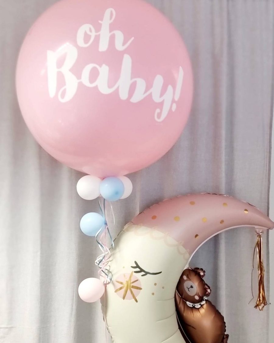 Riesenballon in Rosa mit weißem Schriftzug „oh Baby!“, daneben ein Mondballon in Creme und Altrosa mit schlafendem Bären