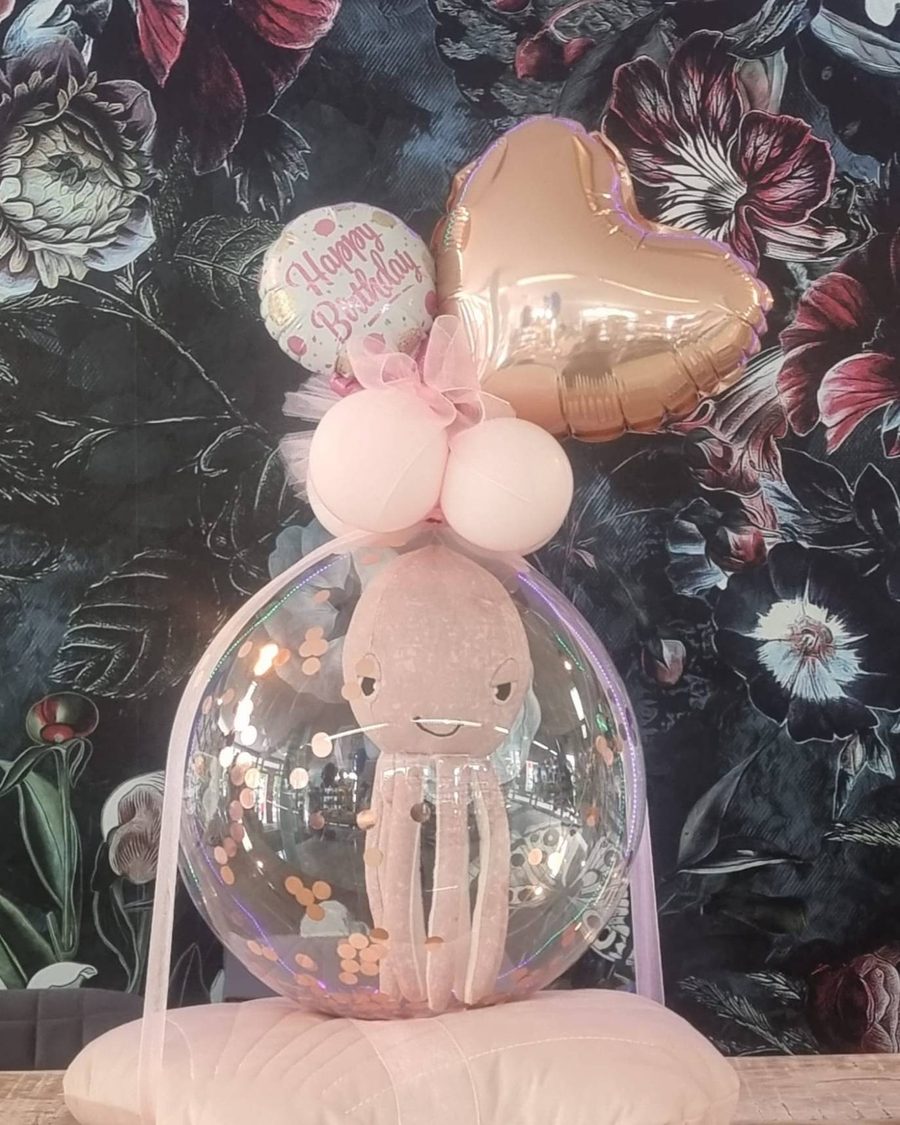 Verpackungsballon: Kuscheltier in einem transparenten Ballon mit Konfetti, dazu Happy-Birthday-Ballon und roségoldenes Herz
